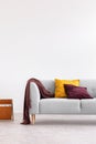 Grey couch with cushions in white minimal living room interior with copy space on the wall. Real photo Royalty Free Stock Photo