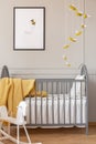 Grey crib, bee decoration and graphic, and rocking horse in a kid room Royalty Free Stock Photo