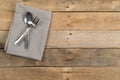 Grey dishcloth with fork and spoon silverware on brown rustic wooden plank table flat lay top view from above Royalty Free Stock Photo