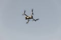 Grey drone with digital camera. Drone hovering in blue sky. Radio control helicopter. Royalty Free Stock Photo