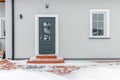 Grey entrance door with glass leading to a private house. Winter, snow Royalty Free Stock Photo