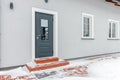 Grey entrance door with glass leading to a private house. Winter, snow Royalty Free Stock Photo