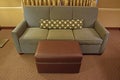 Grey Fabric Sofa with Brown Leather ottoman and long narrow pillow