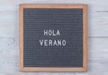 grey felt Board with text in Spanish Hello summer