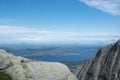 Grey granite cliffs of Seven Sister mountains, Norway with Lovund island and blue Norwegian sea in background Royalty Free Stock Photo