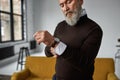 Grey hair caucasian man correcting shirt sleeve