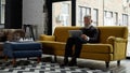 Grey hair caucasian man watching laptop on sofa