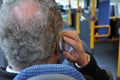 GREY HAIR MALE USES OLD CELLPHONE IN COPENHAGEN