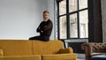 Grey hair man with crossed arms sit on sofa top