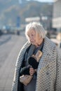 Grey-haired homeless pensioner having only bread to eat