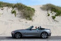 Grey Haired Man in Convertible by Sand Dunes Royalty Free Stock Photo