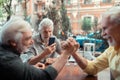 Grey-haired man making photo of friends arm-wrestling Royalty Free Stock Photo