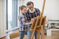 Child enjoying art making with grandpa in home studio