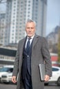 Grey-haired man wearing a grey coat looking good