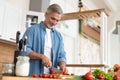 Grey-haired Mature handsome man preparing delicious and healthy food in the home kitchen. Royalty Free Stock Photo