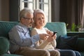 Smiling mature wife and husband using phone at home Royalty Free Stock Photo