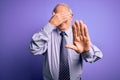 Grey haired senior business man wearing glasses standing over purple isolated background covering eyes with hands and doing stop Royalty Free Stock Photo