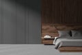 Grey home bedroom interior with bed and nightstand, copy space wall