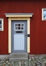 The grey house door in the old red wall Royalty Free Stock Photo