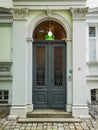 Grey huge entrance doors with ornaments in windows