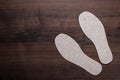 Grey insoles for shoes on wooden background Royalty Free Stock Photo