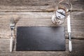 Grey kitchen utensils on rough distressed wooden table: crockery, silverware, cutting board, slate trays and linen towels. Top Royalty Free Stock Photo