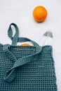 Grey knitted bag handmade, ripe oranges and a bottle of water outdoors. Sustainable shopping. Waste-free lifestyle Royalty Free Stock Photo