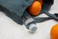 Grey knitted bag handmade, ripe oranges and a bottle of water outdoors. Sustainable shopping. Waste-free lifestyle Royalty Free Stock Photo