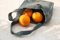 Grey knitted bag handmade and ripe oranges outdoors. Sustainable shopping. Waste-free lifestyle Royalty Free Stock Photo