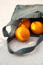 Grey knitted bag handmade and ripe oranges outdoors. Sustainable shopping. Waste-free lifestyle Royalty Free Stock Photo