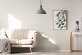 Grey lamp in bright living room interior with poster next to bei