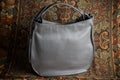 Grey leather bag on background with flowers and abstract patterns, grey leather bag front view, grey ladies leather bag, grey wome Royalty Free Stock Photo