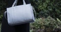 Grey leather texture women bag on female holding, fashion mockup in natural background Royalty Free Stock Photo