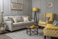 Grey living room with sofa, chairs, standing lamp, small table, yellow details and pattern decorations in black and white Royalty Free Stock Photo