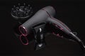 Grey mat hair dryer on the black mirror background with accessory Royalty Free Stock Photo