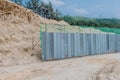 Grey metal fence beside dirt hill