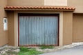 Grey metal garage doors waiting for fresh paint mounted on newly constructed garage wall with new facade next to plastic Royalty Free Stock Photo