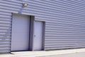 Grey metal roll-down shutters on vertical profiled sheeting gray building fire exit door in commercial industrial unit Royalty Free Stock Photo