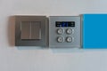 Grey metallic light switch and air condition controller with digital display against white wall
