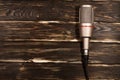 Grey microphone on wooden background.