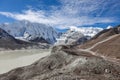 Grey moraine lake and snowy mountain peak in.