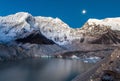 Grey moraine lake and snowy mountain peak in the.