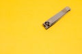 A Grey Nail Clipper in The Corner of Yellow Backrgound Royalty Free Stock Photo