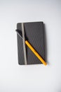 Grey notebook with a orange ballpen on it Royalty Free Stock Photo