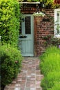 Grey Old Door With Orange Bricky Wall and Green Lavender Garden