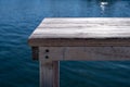 Grey old wooden bench, pier over blue sea background