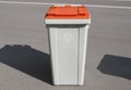 Grey and orange garbabe can in the street Royalty Free Stock Photo