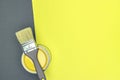 Grey paintbrush with can of yellow paint. renovation concept. top view Royalty Free Stock Photo