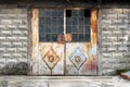 Grey partially rusted metal doors with small door handle and broken safety wire protection glass mounted on concrete wall Royalty Free Stock Photo