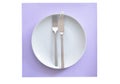 Grey plate and cutlery on mauve